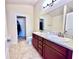 Bathroom with double vanity, granite countertops, tile flooring and walk-in closet at 1171 Legatto Loop, Dundee, FL 33838