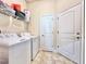 Bright laundry room featuring a washer, dryer, wire rack shelf and tile flooring at 1171 Legatto Loop, Dundee, FL 33838