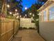 Enchanting backyard with string lights, a wooden fence, brick pavers, and lush greenery for a serene outdoor space at 209 E 4Th St, Sanford, FL 32771
