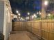 Beautiful backyard with string lights, wooden fence, brick pavers, and a private, tranquil atmosphere at twilight at 209 E 4Th St, Sanford, FL 32771
