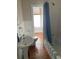 Classic bathroom featuring a toilet, tub, and pedestal sink with blue shower curtain, and natural light at 209 E 4Th St, Sanford, FL 32771