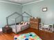 Bright bedroom featuring playful decor, hardwood floors, and natural light at 209 E 4Th St, Sanford, FL 32771