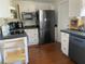 Functional kitchen featuring appliances, white cabinetry, dark countertops, and ample counter space for cooking at 209 E 4Th St, Sanford, FL 32771