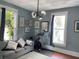 Cozy living room featuring hardwood floors, large windows, and comfortable seating with a modern chandelier at 209 E 4Th St, Sanford, FL 32771