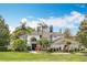 Elegant two-story home featuring a tiled roof, arched entryway, lush landscaping, and a well-manicured lawn at 2540 Hempel Cove Ct, Windermere, FL 34786