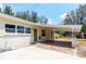 Home exterior featuring carport, neutral paint, green door, and brick accents at 2637 Florence St, Orlando, FL 32818