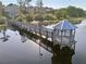Scenic aerial view of a gazebo and fishing pier on the lake with calm water and reflective lighting at 3480 Soho St # 107, Orlando, FL 32835