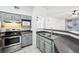 Bright kitchen featuring stainless steel appliances, dark counters, a breakfast bar, and neutral paint palette at 3480 Soho St # 107, Orlando, FL 32835