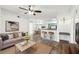 An open concept living room featuring a fan, breakfast bar, hardwood floors, and a light neutral color palette at 3480 Soho St # 107, Orlando, FL 32835