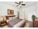 Spacious main bedroom with a ceiling fan, hard wood floors, neutral paint and ensuite bathroom at 3480 Soho St # 107, Orlando, FL 32835