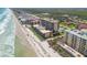 Breathtaking aerial view showcasing beachfront condos, sandy shores, and sparkling ocean waters at 4139 S Atlantic Ave # B707, New Smyrna Beach, FL 32169