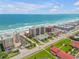 Expansive aerial view of pristine oceanfront condos with convenient beach access and recreational tennis courts, perfect for leisure at 4139 S Atlantic Ave # B707, New Smyrna Beach, FL 32169