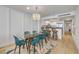 Bright dining area features a modern glass table, blue chairs, and a stylish chandelier at 4139 S Atlantic Ave # B707, New Smyrna Beach, FL 32169
