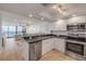 Bright kitchen features stainless steel appliances, white cabinets, and a breakfast bar that opens to the living area at 4139 S Atlantic Ave # B707, New Smyrna Beach, FL 32169