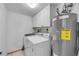 Functional laundry room with modern washer, dryer, and water heater, plus cabinet storage at 4139 S Atlantic Ave # B707, New Smyrna Beach, FL 32169