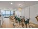Open-concept dining and living area with floor-to-ceiling windows, modern furniture, and stylish decor at 4139 S Atlantic Ave # B707, New Smyrna Beach, FL 32169