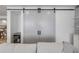 Living room with sliding barn doors, a bar area, and a comfortable sofa, creating an inviting atmosphere at 4139 S Atlantic Ave # B707, New Smyrna Beach, FL 32169