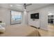 Cozy bedroom with a TV, dresser, and access to the living room and kitchen, offering modern living at 4139 S Atlantic Ave # B707, New Smyrna Beach, FL 32169
