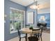 Bright dining area with a round table and artwork, leading to another dining space at 4306 Pebblestone Ct, Orlando, FL 32826