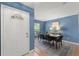 Dining room featuring blue walls, a modern table set, and natural light from the nearby window at 4306 Pebblestone Ct, Orlando, FL 32826
