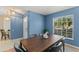 Dining room with a window and a dark wooden table set against the blue walls at 4306 Pebblestone Ct, Orlando, FL 32826
