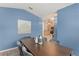 Dining room with blue accent wall, wooden table, and a view into the kitchen at 4306 Pebblestone Ct, Orlando, FL 32826