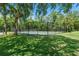 Community tennis court surrounded by lush landscaping for privacy and shade at 4306 Pebblestone Ct, Orlando, FL 32826
