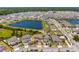 Aerial view shows a beautiful neighborhood near a lake, featuring neatly arranged homes with well-maintained lawns at 5637 Beggs Road, St Cloud, FL 34771
