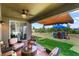 Covered patio with seating and outdoor awning offers relaxation overlooking the lush backyard and an outdoor dining area at 5637 Beggs Road, St Cloud, FL 34771