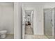 Hallway view from the toilet to main bedroom suite, featuring tile floors and a shower with glass doors at 5637 Beggs Road, St Cloud, FL 34771