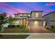 Beautiful two-story home featuring a brick driveway, attached two-car garage, and manicured landscaping at 5637 Beggs Road, St Cloud, FL 34771