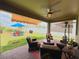 Covered outdoor patio featuring comfortable seating, a ceiling fan, and a view of the backyard, ideal for relaxation at 5637 Beggs Road, St Cloud, FL 34771
