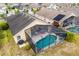 Aerial view featuring the enclosed pool, covered patio, and well-manicured yard at 650 Old Bridge Cir, Davenport, FL 33897