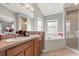 Bathroom showcasing a double sink vanity, a soaking tub, a walk-in shower, and natural light from a window at 650 Old Bridge Cir, Davenport, FL 33897