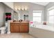 Bright bathroom featuring a double sink vanity, a soaking tub, a toilet, and ceramic tile flooring for a clean and functional space at 650 Old Bridge Cir, Davenport, FL 33897