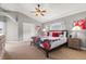 Bedroom featuring a bed with floral-patterned bedding, accompanied by wooden nightstands and carpeted flooring at 650 Old Bridge Cir, Davenport, FL 33897