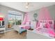 Bright bedroom featuring two twin beds with pink canopies and a large window at 650 Old Bridge Cir, Davenport, FL 33897