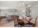 Elegant dining area featuring a wood table, chandelier, and an open view to the living room at 650 Old Bridge Cir, Davenport, FL 33897