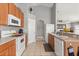 Well-equipped kitchen with wood cabinets, tile floors, and white appliances for a clean look at 650 Old Bridge Cir, Davenport, FL 33897