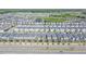 Extensive aerial view of a vibrant neighborhood with uniform houses, pools and a serene pond, all bathed in sunlight at 820 Overpool Ave, Davenport, FL 33896