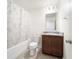 Bright bathroom featuring a shower with a leaf-patterned curtain, toilet, and granite sink vanity with a mirror above at 820 Overpool Ave, Davenport, FL 33896