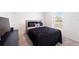 This bedroom features a neatly made bed with black bedding and window for natural light at 820 Overpool Ave, Davenport, FL 33896