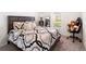 Bedroom featuring a well-made bed with patterned cover, a window, a mirror, and a chair with a teddy bear on it at 820 Overpool Ave, Davenport, FL 33896