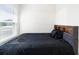 This main bedroom features an attractive dark bed frame with dark bedding and a large window at 820 Overpool Ave, Davenport, FL 33896