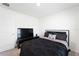 Bedroom showcasing a bed with black bedding, a modern TV setup, and plenty of open space at 820 Overpool Ave, Davenport, FL 33896