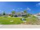 View of a clubhouse in a landscaped community setting with mature trees and a playground in the background at 820 Overpool Ave, Davenport, FL 33896