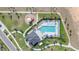Aerial view of a community pool with sun loungers, lush landscaping, playground, and a clubhouse at 820 Overpool Ave, Davenport, FL 33896