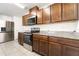 Kitchen featuring stainless steel appliances, granite countertops, wooden cabinetry, and tile flooring at 820 Overpool Ave, Davenport, FL 33896