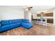 Open-concept living room with a blue sofa, modern flooring, and a kitchen featuring granite countertops at 820 Overpool Ave, Davenport, FL 33896