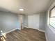 This bedroom features new wood flooring, a closet, and a window at 969 Chestnut St, Clermont, FL 34711